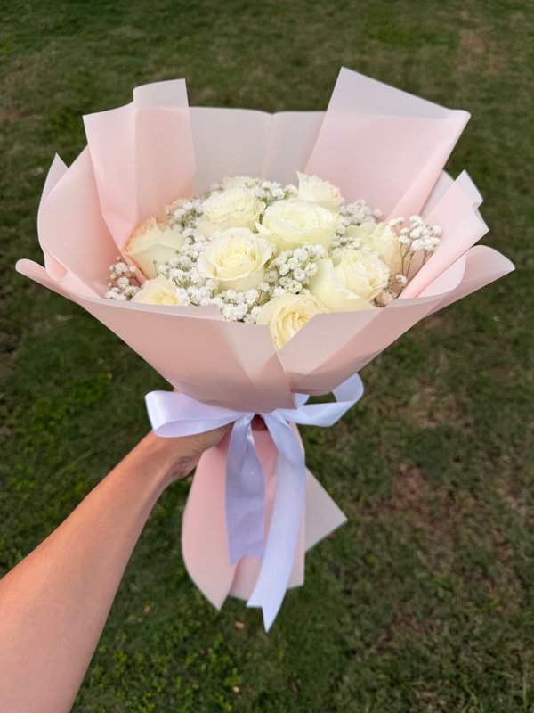 Ramo de 12 rosas blancas con baby's breath en wrap rosa